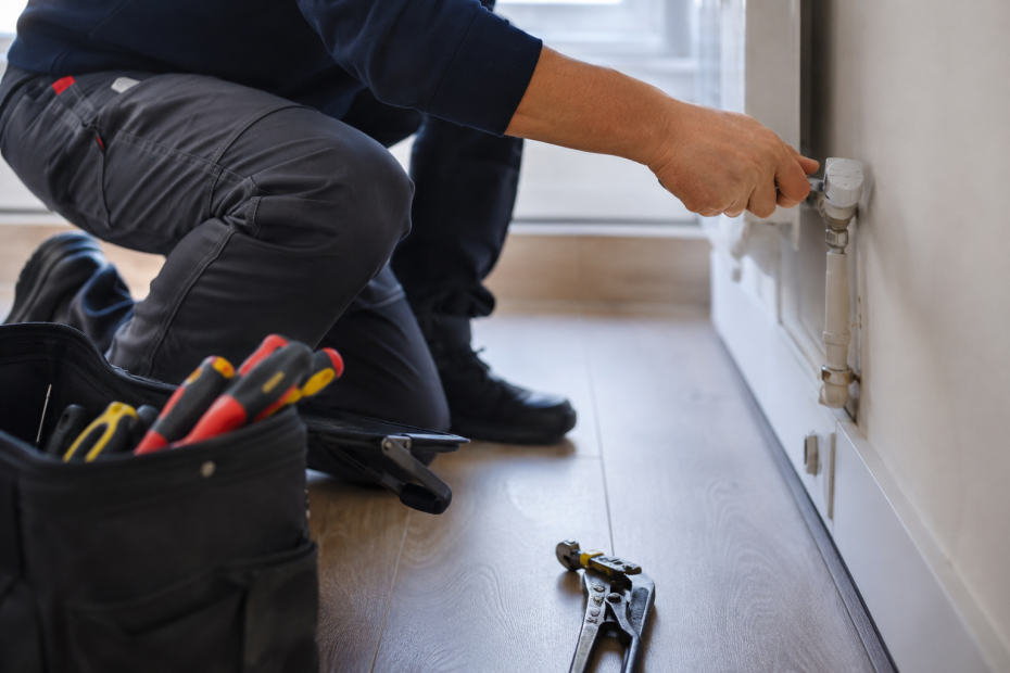Intervention de maintenance des bâtiments avec réglage d’un radiateur et outils professionnels.